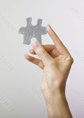 Hand holding puzzle piece