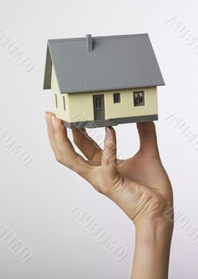 Hand holding miniature house
