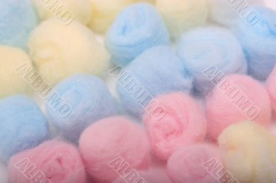 Blue, yellow and pink hygienic cotton balls in rows