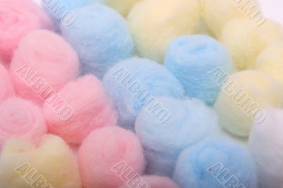 Blue, yellow and pink hygienic cotton balls in rows