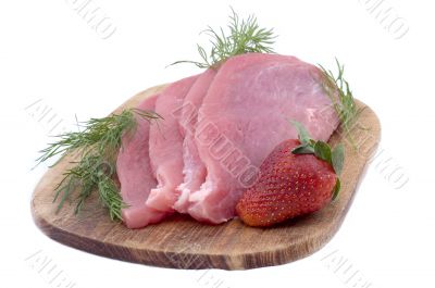 Raw pork schnitzel with dill and a strawberry