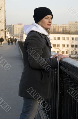 The thoughtful pretty womanl on the bridge