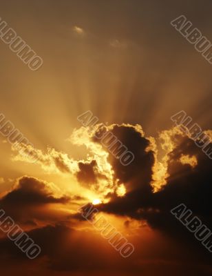 dramatic sundown scene with dark clouds and rays