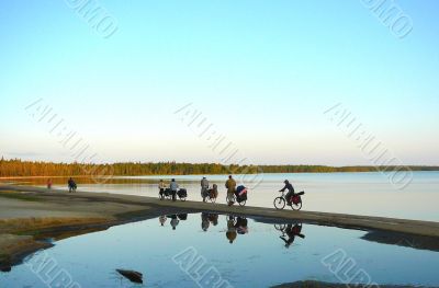 bicyclists between sky &amp; water