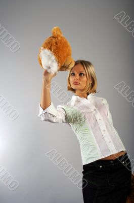 Young woman playing with the teddy bear`s head