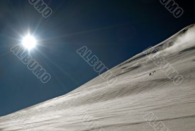 Five people trekking  to a top of mountain.