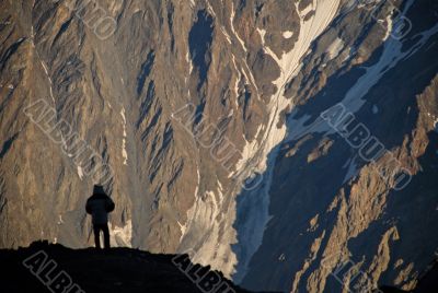 Silhouette of a man over a rock.