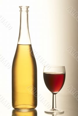 Yellow bottle with a full beaker of red wine. Yellow bottle with a full beaker of red wine.