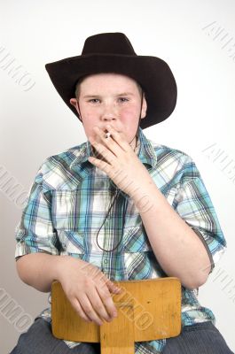 young handsome cowboy smoking a cigarette young handsome cowboy smoking a cigarette