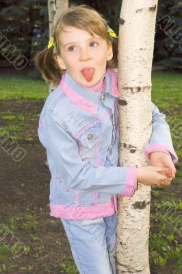 The girl in a blue dress plays with birches