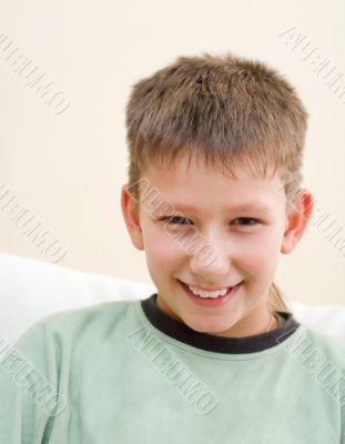 Smiling teenager sit on white sofa