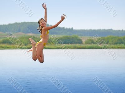 Girl jumping above water smooth surface