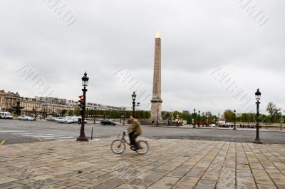 Young man riding bicycle near Obelisk Young man riding bicycle near Obelisk