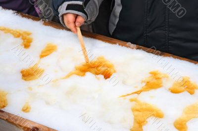 Child putting on a sick maple taffy