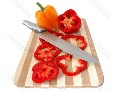 Red and yellow paprika on bamboo cutting board.