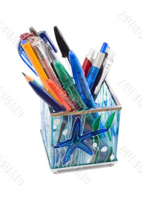 Glass pen holder with pens, isolated on white