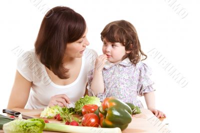 mother and daughter cooking at the kitchen