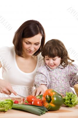 mother and daughter cooking at the kitchen