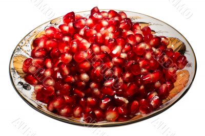 Pomegranate grains on a plate. Isolated on white. Pomegranate grains on a plate. Isolated on white.