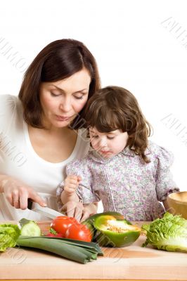 mother and daughter cooking at the kitchen