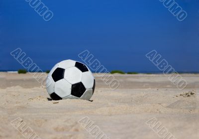 Soccer ball on sandy beach