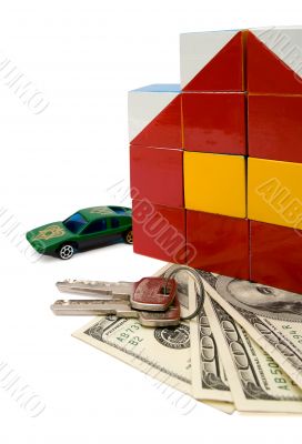 Toy house and a car over a bunch of dollars, isolated with clipp