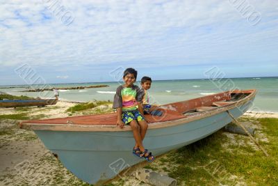 two kids relaxing on top of a fishing boat
