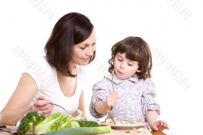 mother and daughter cooking at the kitchen