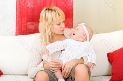 Mother hold her baby girl at home