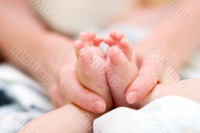 Mother gently massage baby`s legs