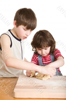 children in the kitchen making a dough