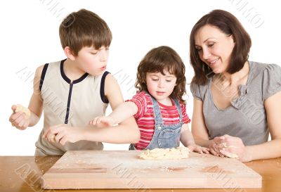 mother and children in the kitchen making a dough