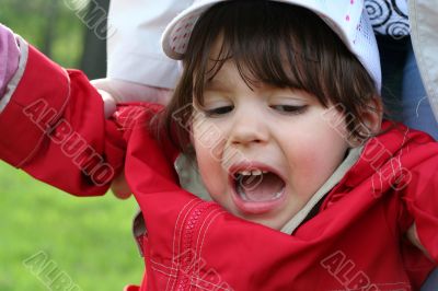 little girl is crying outdoors in spring park