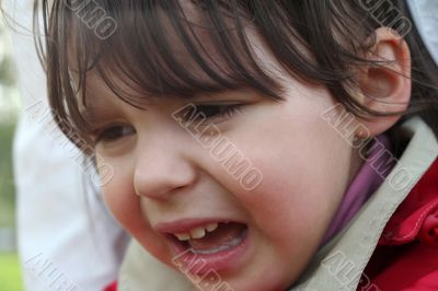 little girl is crying outdoors in spring park