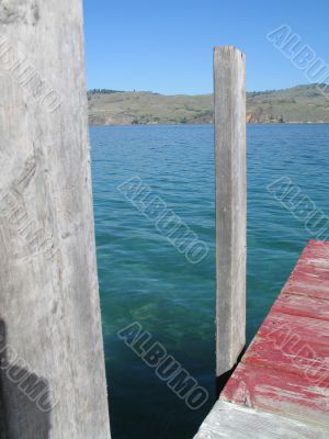 dock on the edge of a green lake