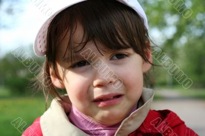 Offended and crying little girl in the park