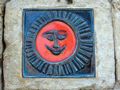 detail of a stone sun figure on wall