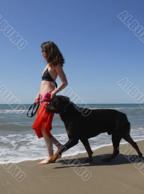 woman and rottweiler on the beach