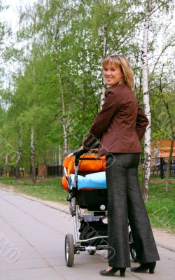 Happy mom with the son in a carriage