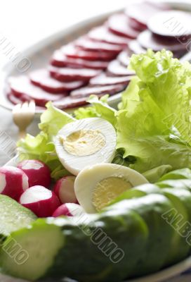 salad and sausage in the plate