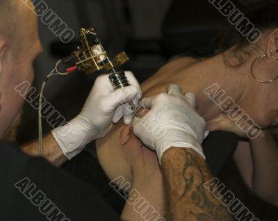 a man tattooing a woman
