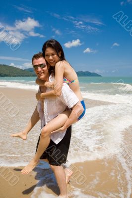 hunk carrying woman piggyback style ath beach