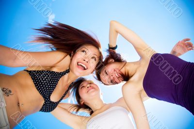 happy girls friends having fun under bright blue sky