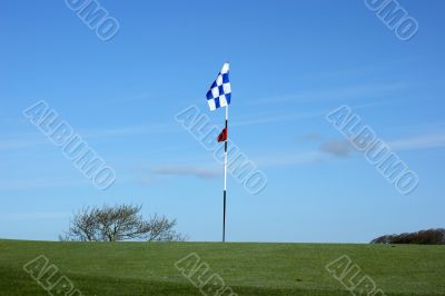 Golf flag on the blue sky