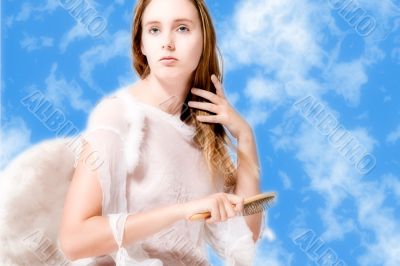 Beautiful angel in the clouds doing her hair