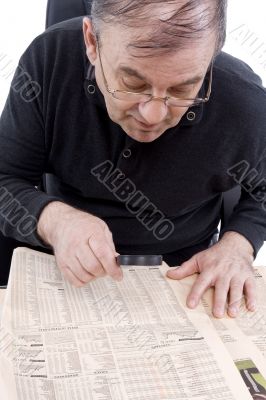 Senior read newspaper with magnifying glass