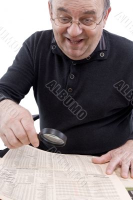 Senior read newspaper with magnifying glass Senior read newspaper with magnifying glass