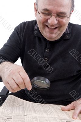 Senior read newspaper with magnifying glass