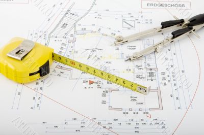 Building plan with pair of compasses and rolling meter