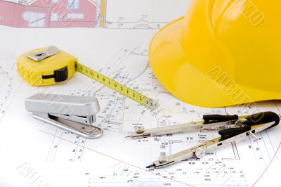 Building plan with safety helmet, pair of compasses and rolling